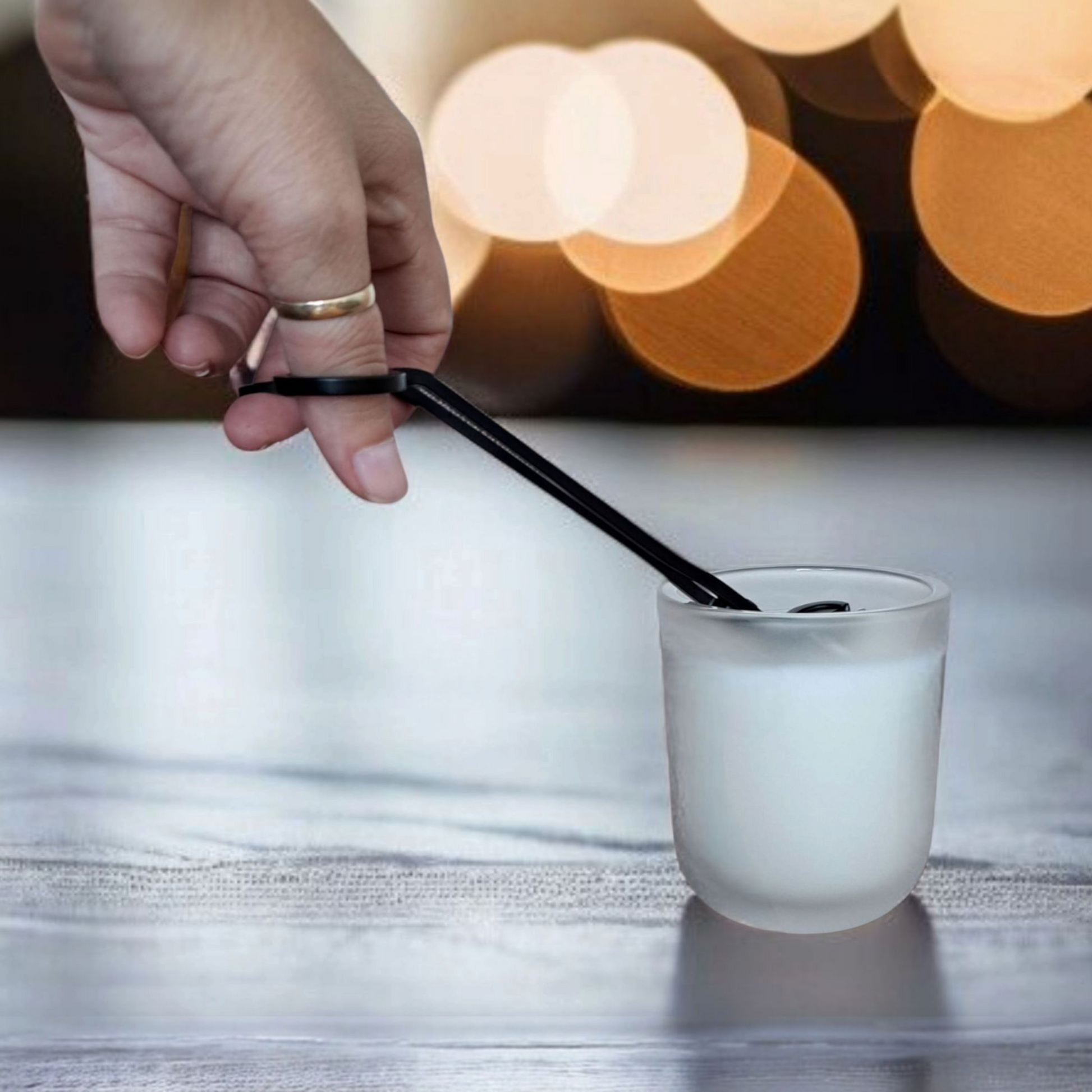 Hand trimming luxury soy Orriswood candle wick with blurred lights