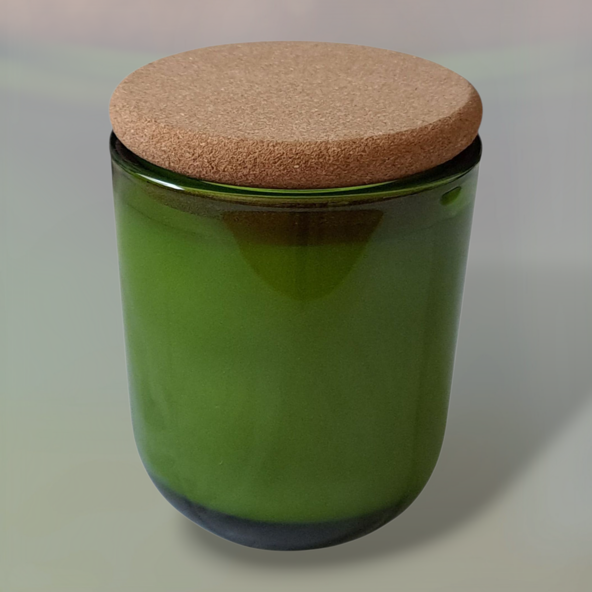 Green glass Fogborn candle with cork lid and light grey background