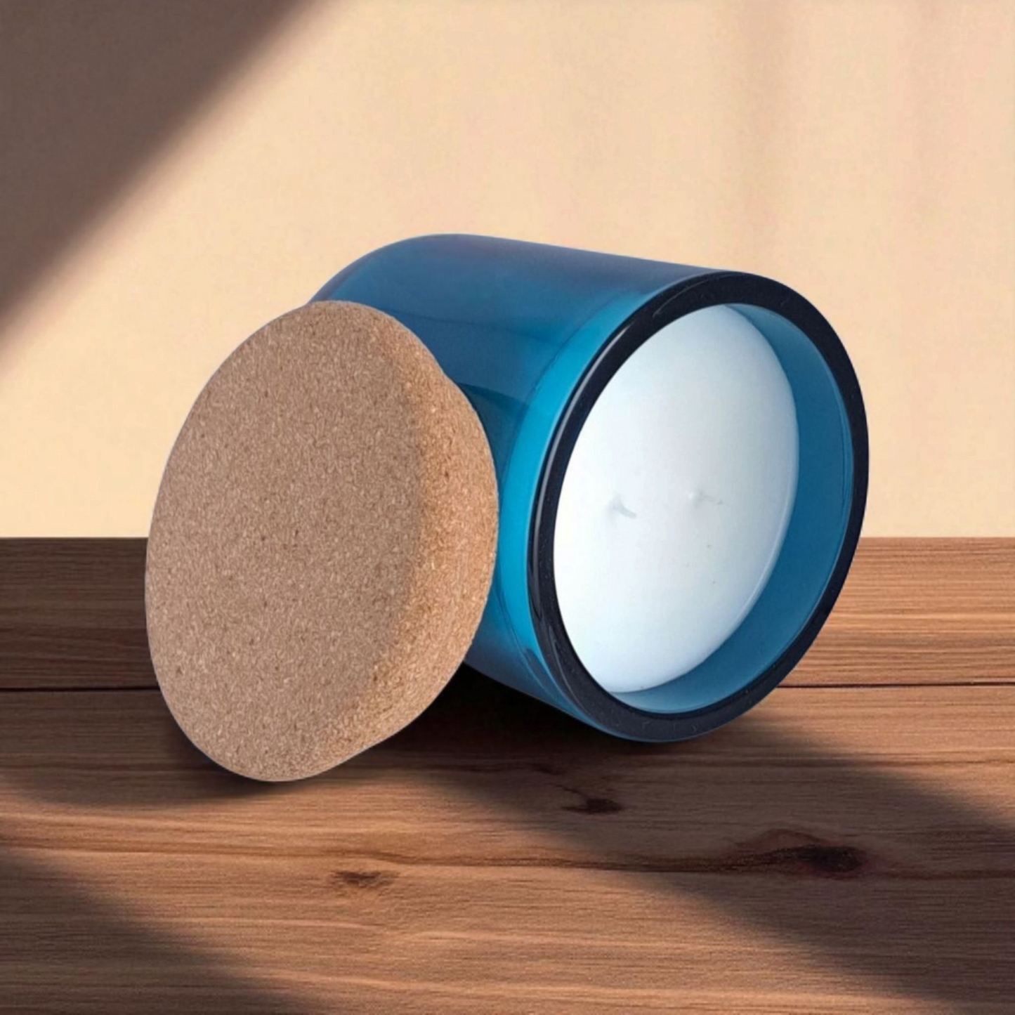 Close-up of blue Saltmere candle with cork lid on wooden surface