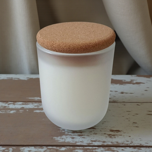 Orriswood frosted white glass candle with cork lid on rustic wooden table with soft drapes in the background