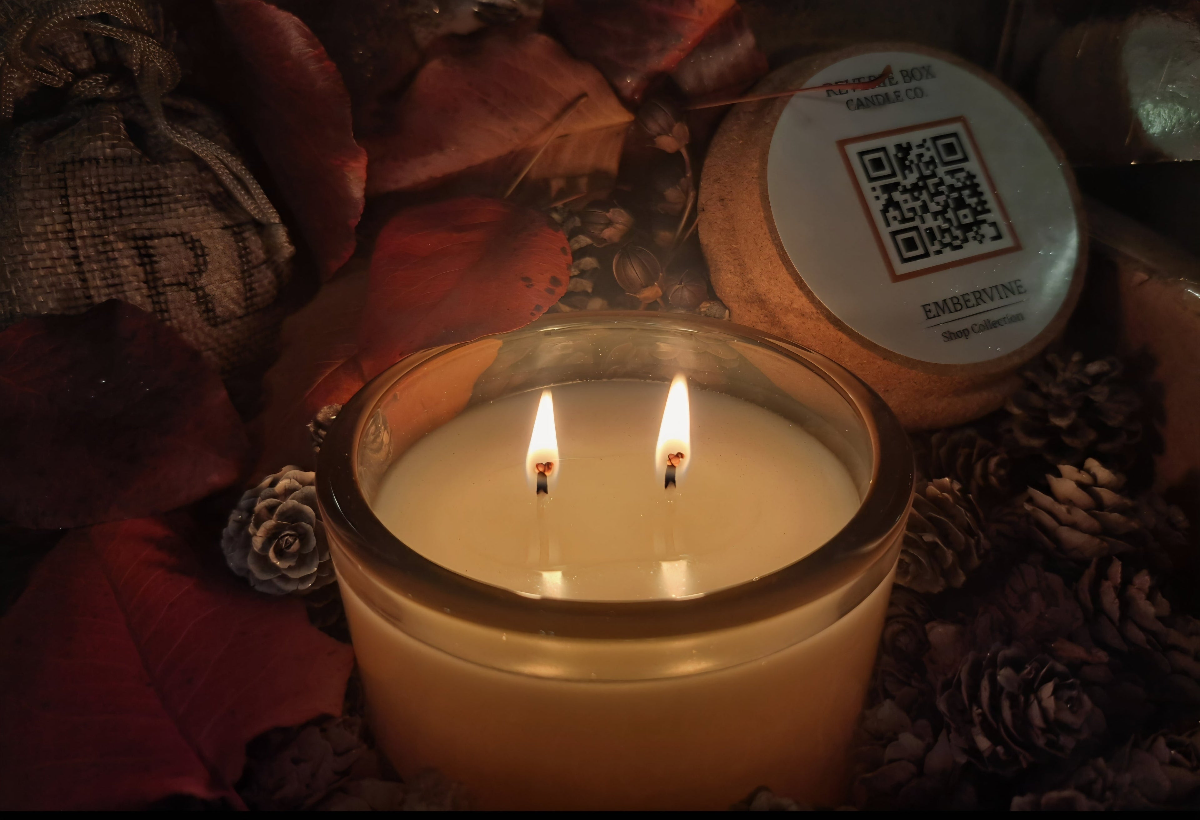 Candle with two flames with a rustic surface and branded lid in background