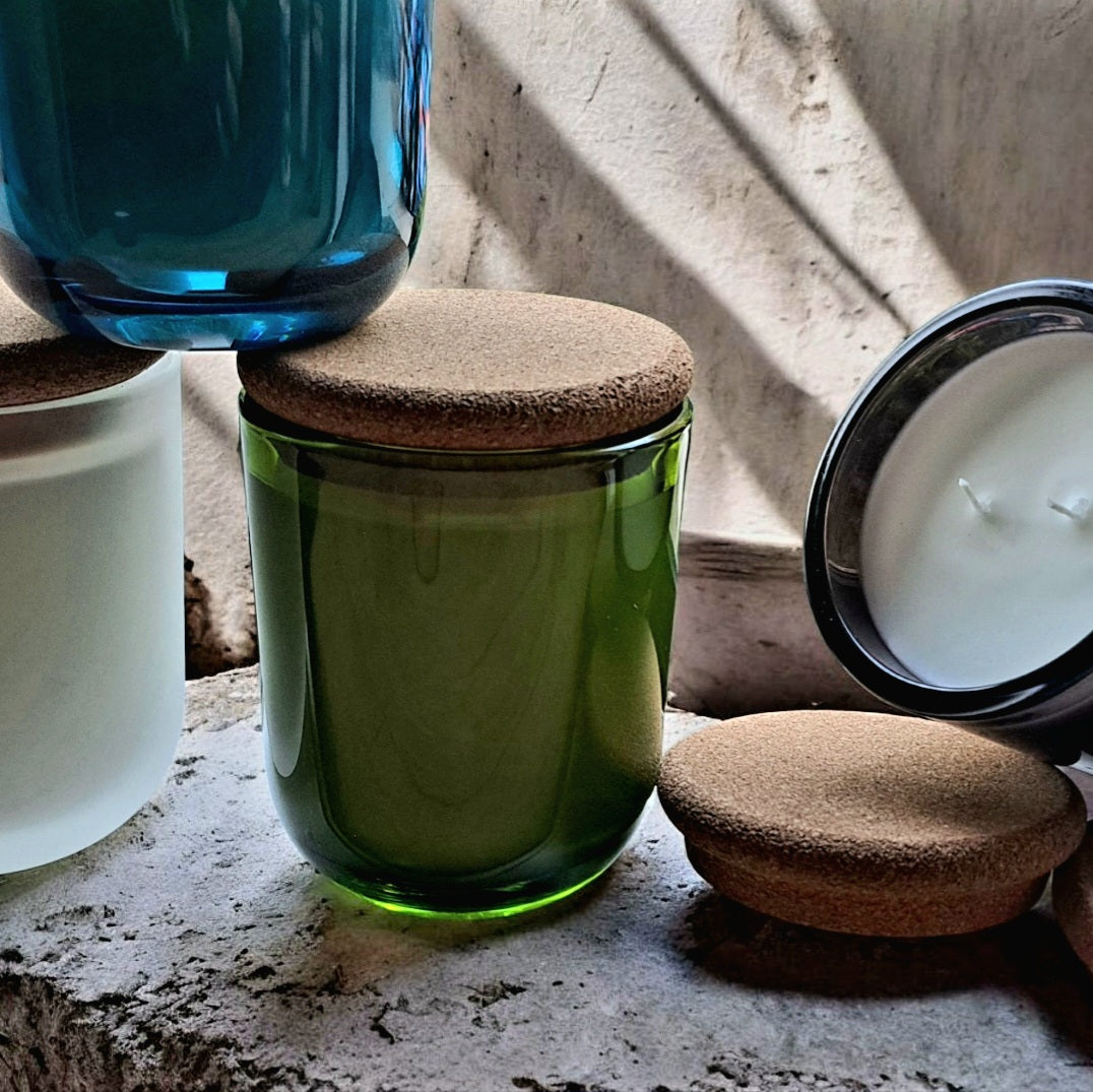 Reverie Box jewel-toned glass vessels with natural cork lids and sunlight