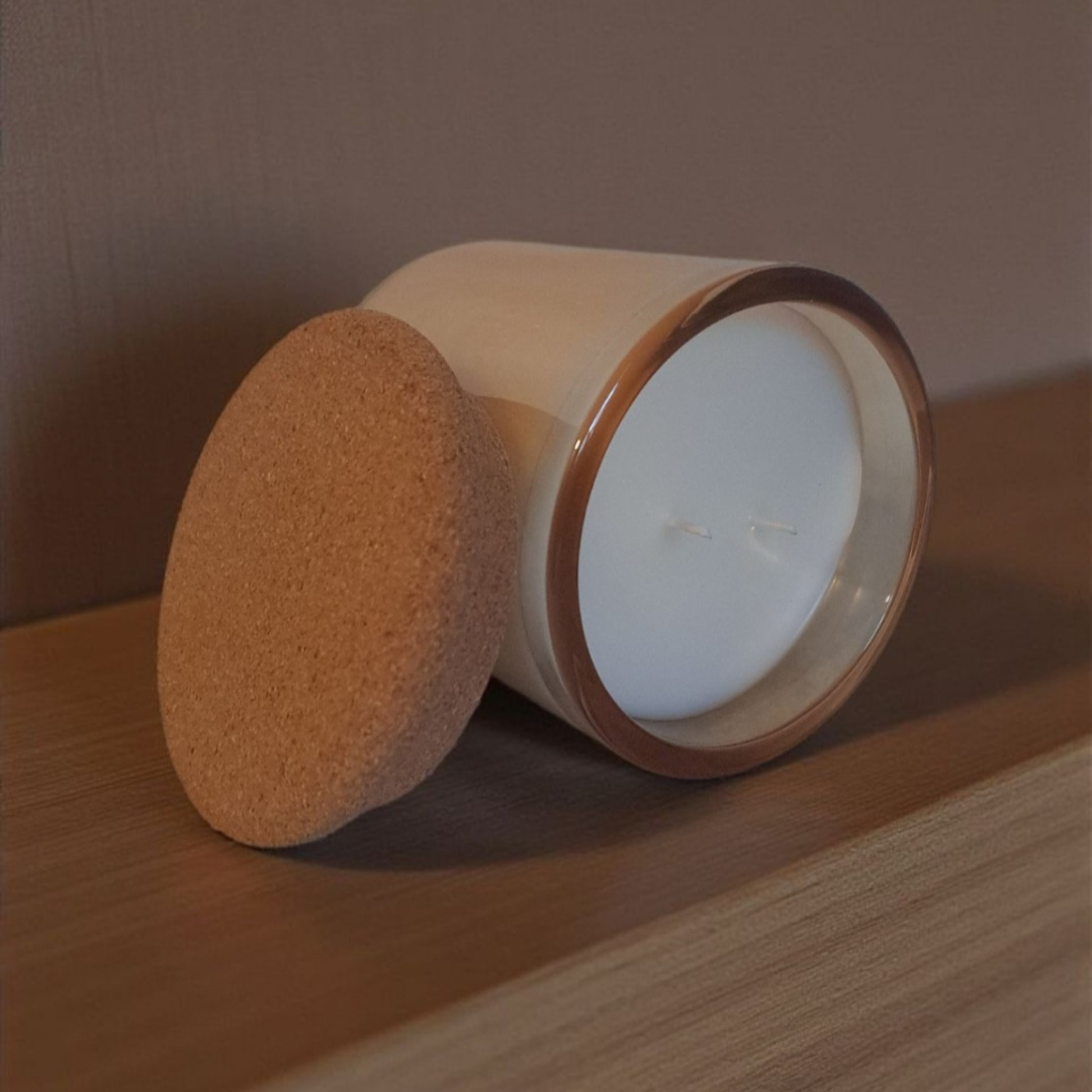 Detail shot of Embervine smooth wax surface with double wicks and cork lid on wooden surface