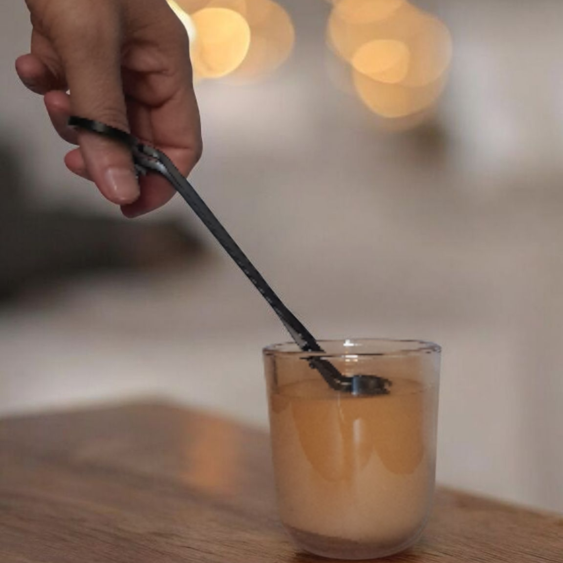 Hand trimming Embervine candle wick with wick trimmer luxury candle care