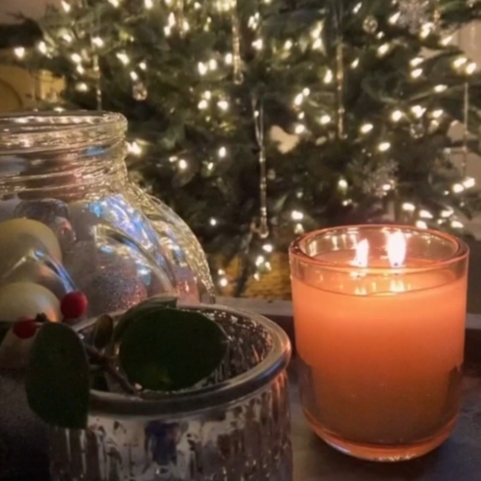 Limited edition New Year Embervine candle close-up on wooden surface with tree lights in background