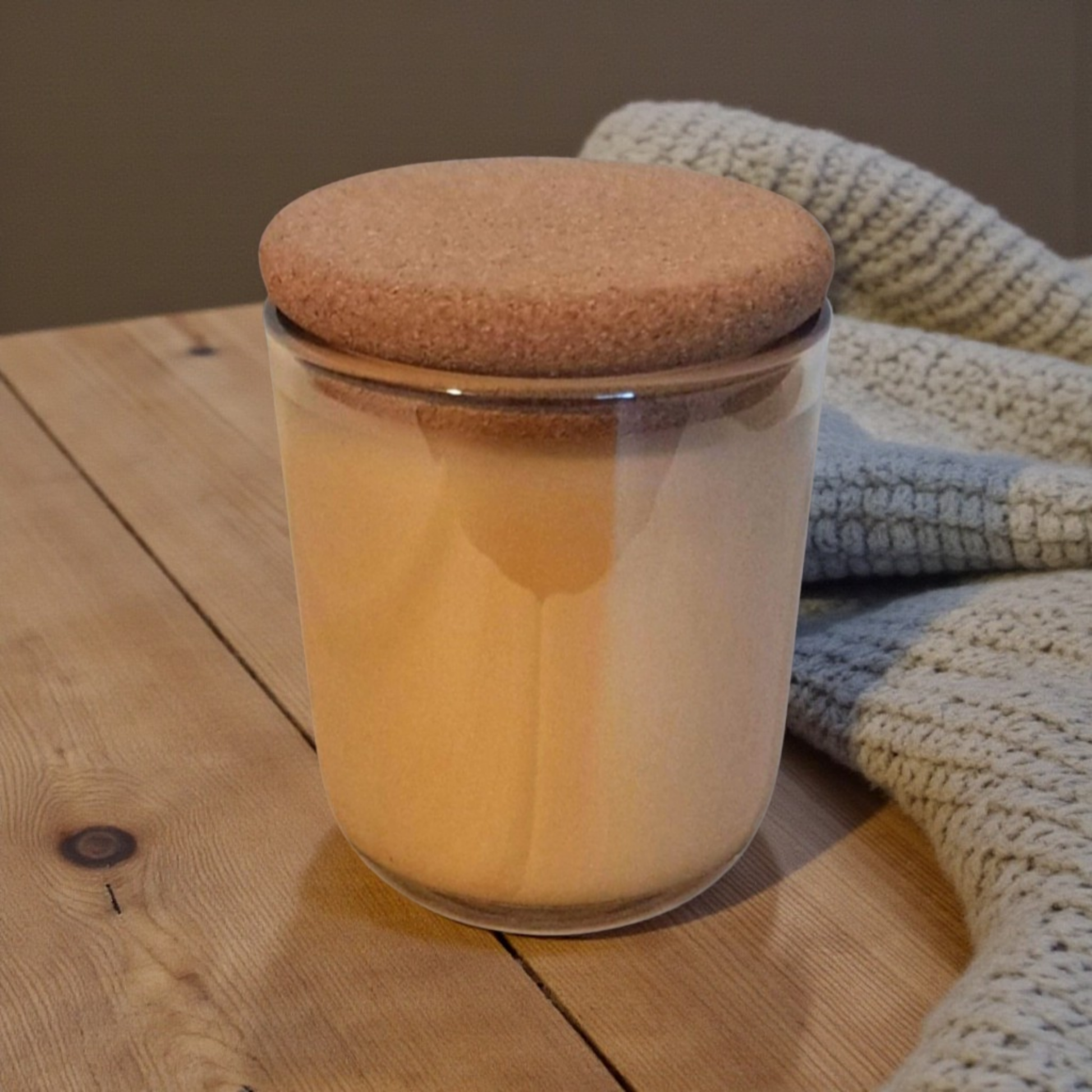 Embervine champagne glass vessel with cork lid on wooden table with knit blanket